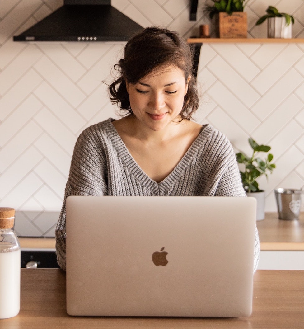 Asian woman smiling while using a laptop